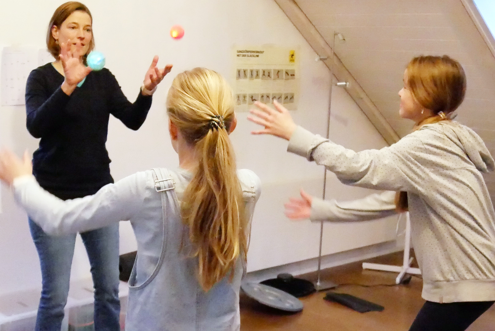 Barbara Stalder bei einem Bewegungsspiel mit Bällen während einer body'n brain-Session mit zwei Kindern
